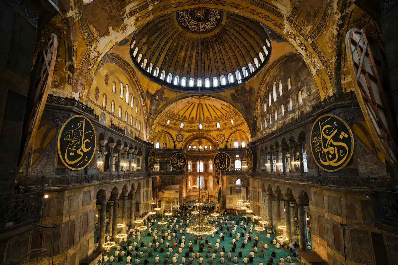 Het interieur van de Hagia Sophia in Istanbul, met de grote koepel en gouden mozaïeken.